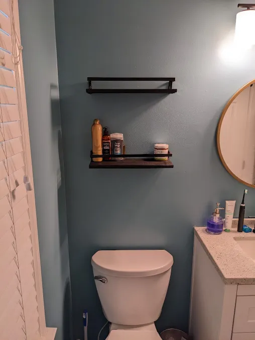 A shelf has been installed above the toilet to hold extra toiletries