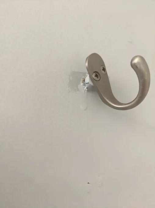 A closeup of one such hook, pulled partially out of the wall by the weight of some soap