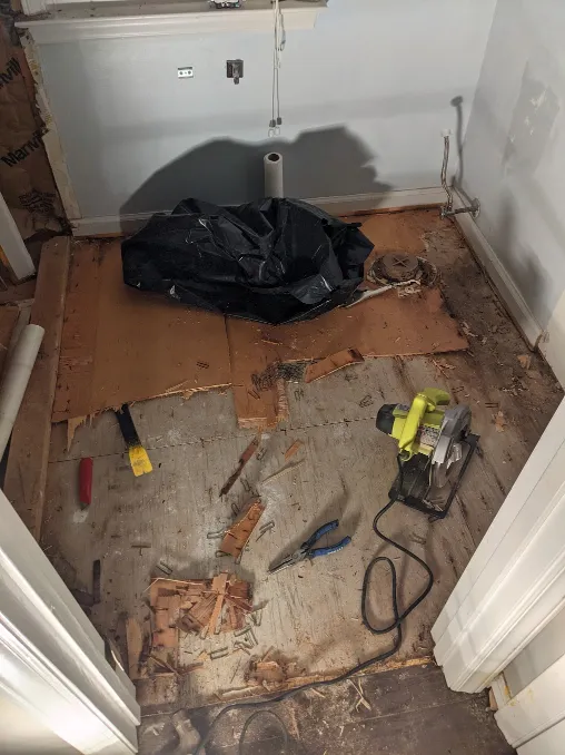 more of the wooden underlayment is gone. The hand tools have been swapped for electric ones.