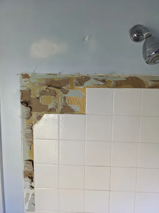 Tiles glued to a damaged wall