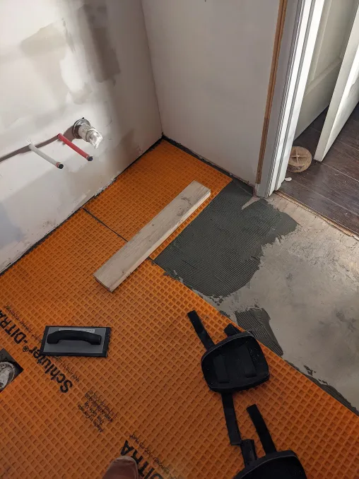 More orange sheets are cemented in place. A plank is being used to smooth the top of the sheet