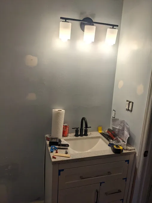 A light has been installed using that box. A new vanity is being tested beneath it