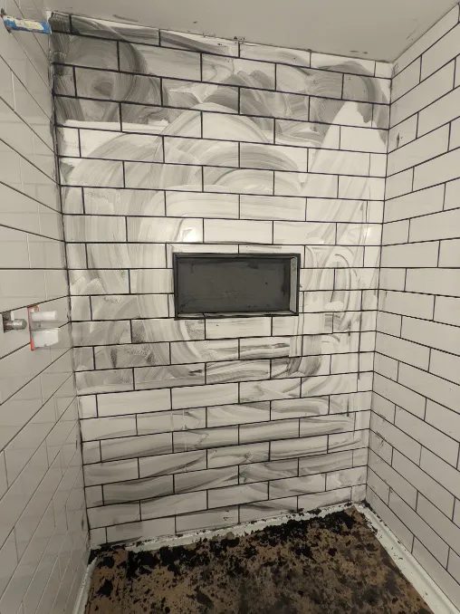 Some of the grout has been wiped away, but it still stains the walls