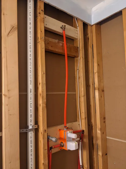 A second block has been added to the wall, allowing the shower head to be even higher