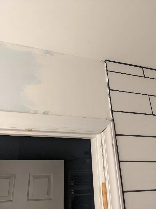 Drywall mud has been used to smooth the transition from tile to drywall around the shower