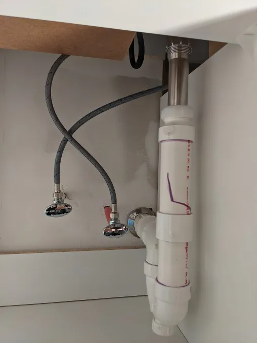 Pipes from the wall are connected to the new faucet