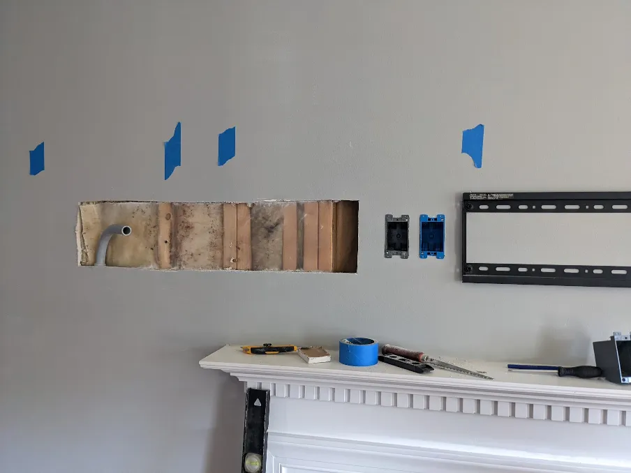 Old work electrical boxes have been installed next to the hole