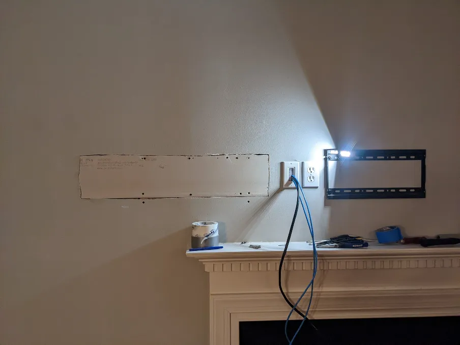 A drywall patch has been placed in the hole. Outlet covers have been added to the electrical boxes