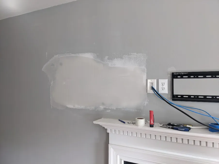 The drywall mud has dried and been sanded smooth. Another layer of mud is visible atop it